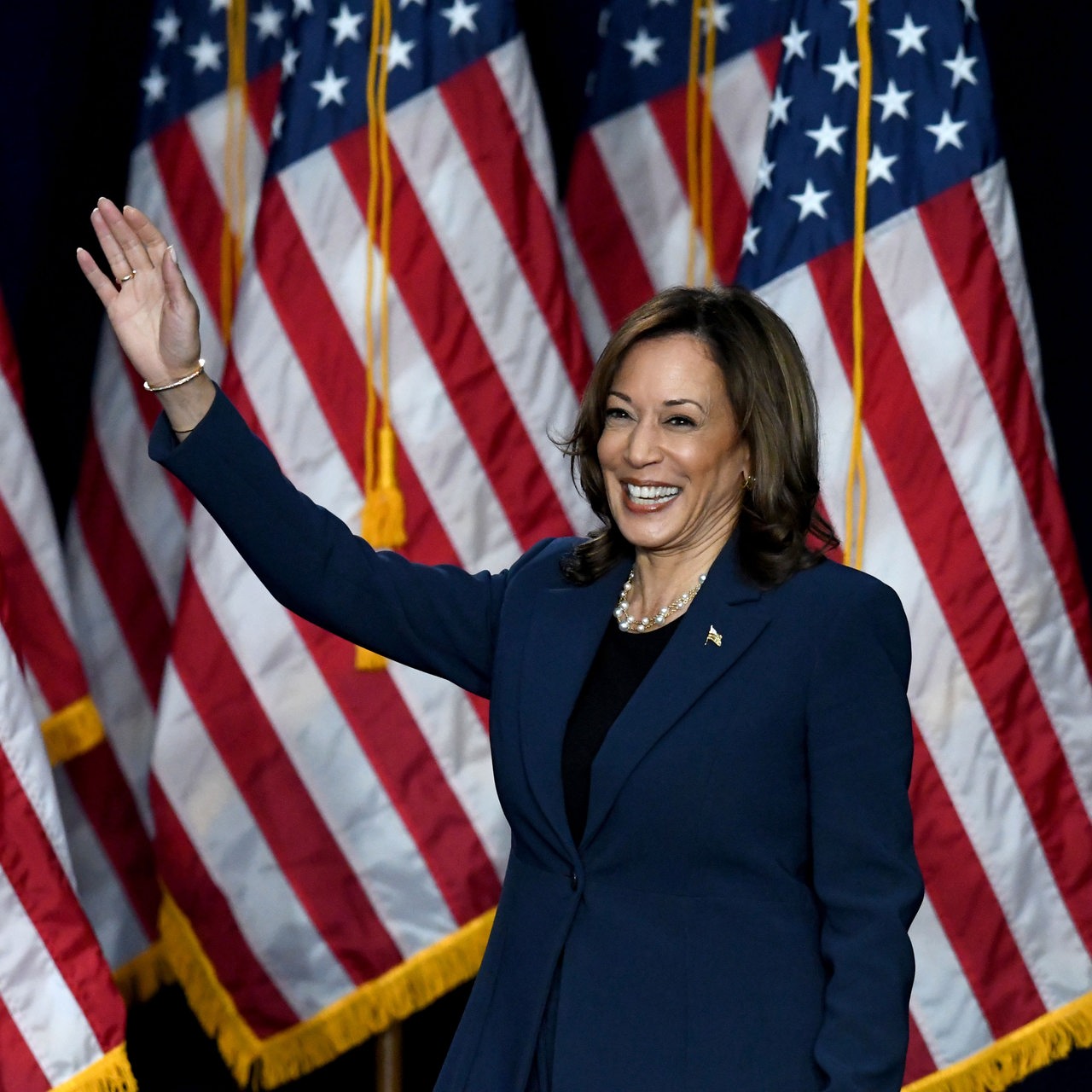 Kamala Harris lächelt und winkt.