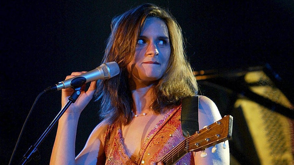 Madeleine Peyroux steht mit Gitarre am Mikrofon - Konzert 2005 in Spanien