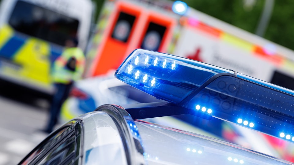 Das Blaulicht eines Einsatzfahrzeuges der Polizei, im Hintergrund ein Rettungswagen und ein Mannschaftswagen