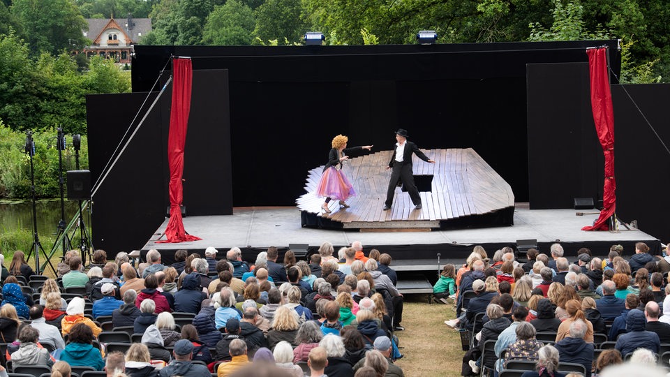 Zuschauer sitzen im Bremer Bürgerpark bei einer Vorstellung von "Shakespeare im Park" der Shakespeare Company