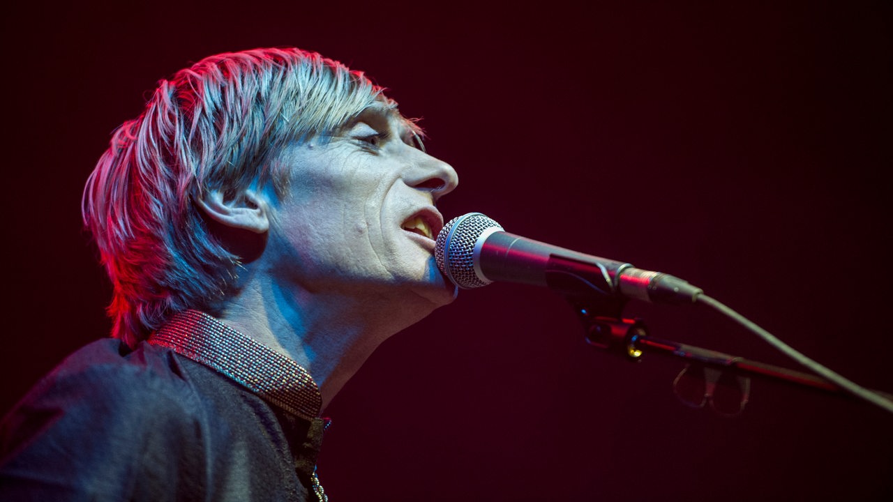 Der Musiker Kula Shaker singt ins Mikrofon.